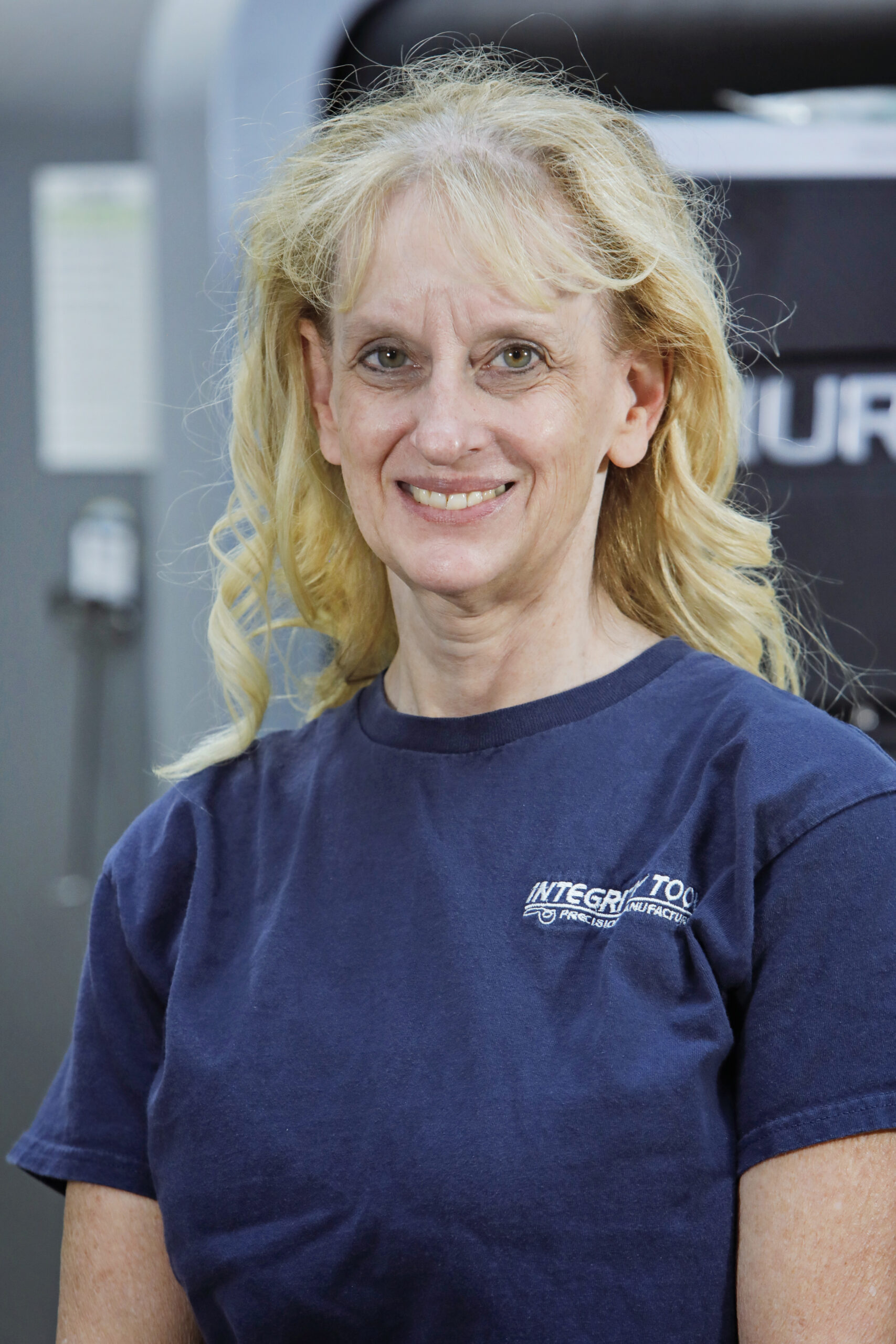 An woman is standing wearing Integrity Tool t shirt