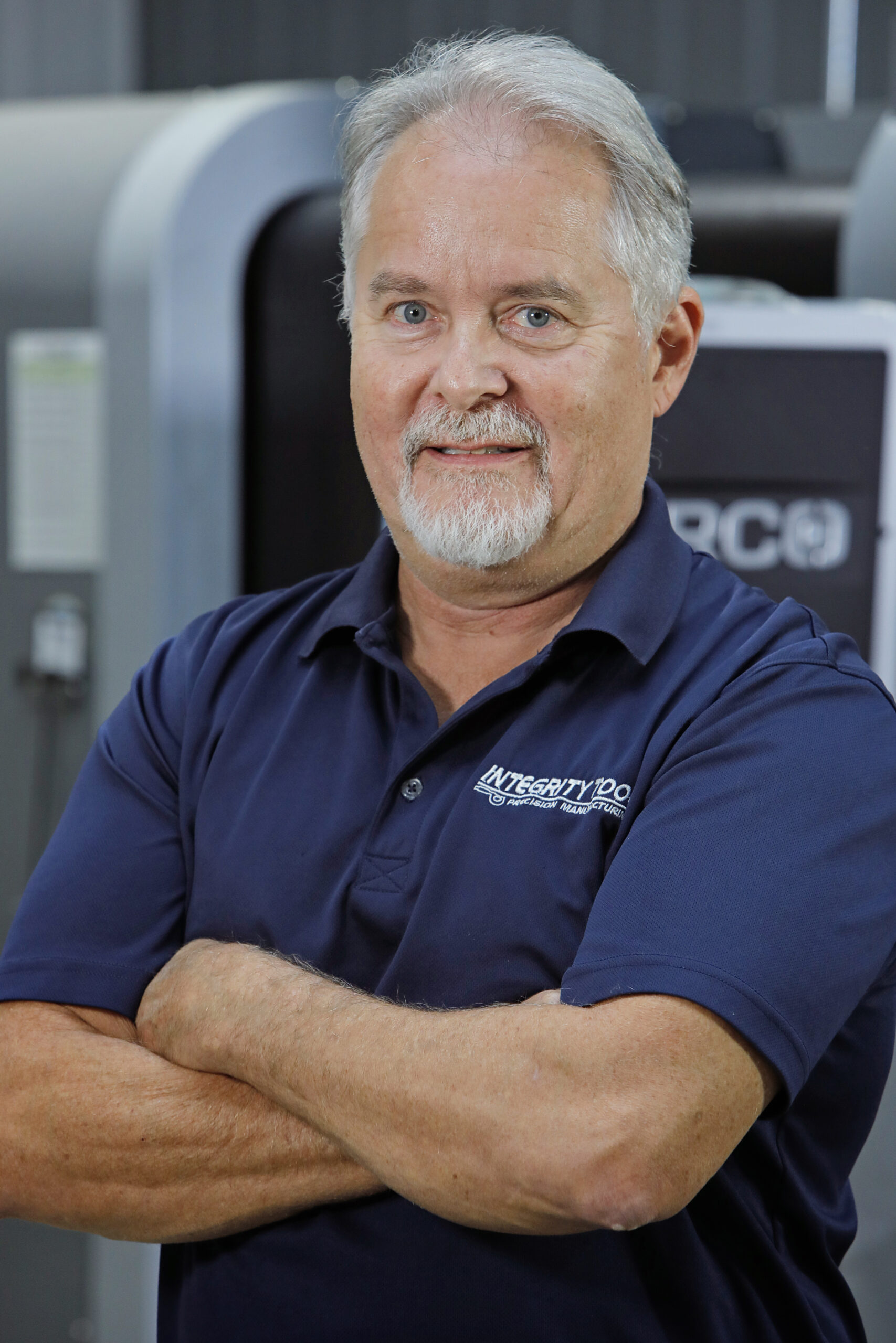 An old man is standing wearing Integrity Tool t shirt